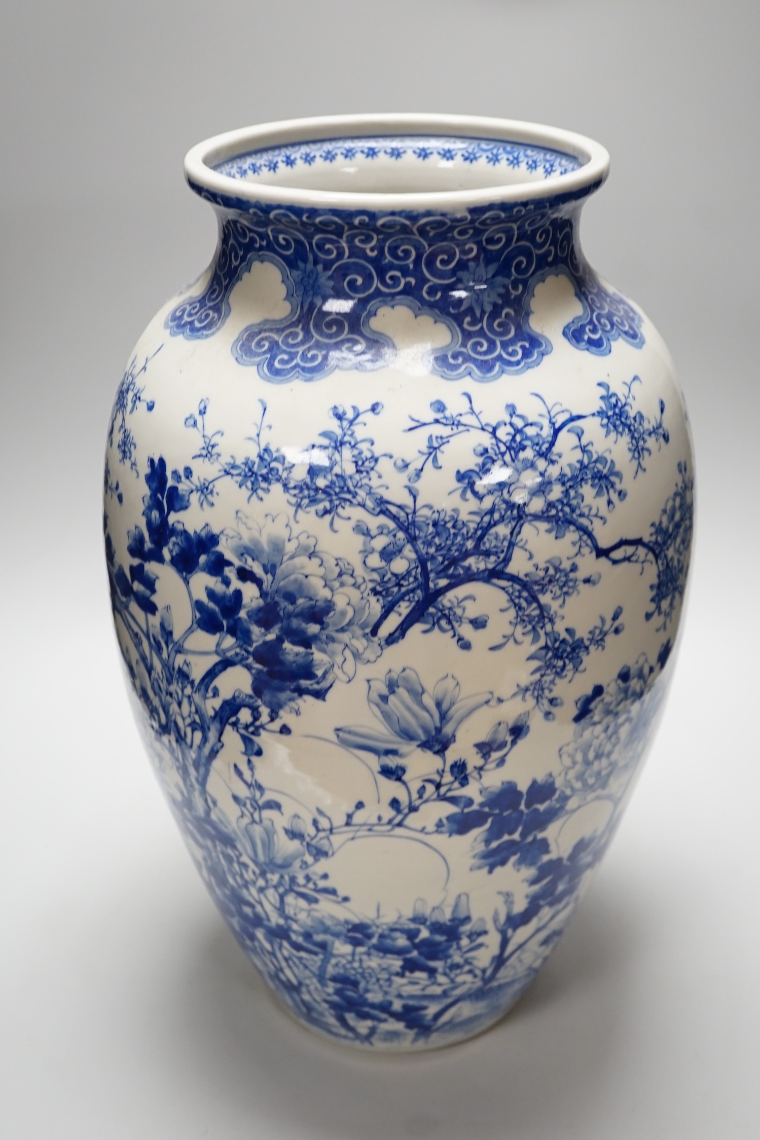 A large Japanese blue and white vase decorated with foliage and birds, 49cms high